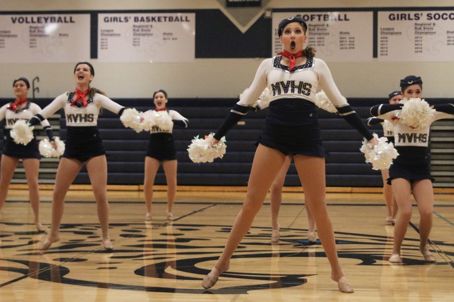 Arms out, senior Addie Ward performs in the pom routine on Saturday, March 30.