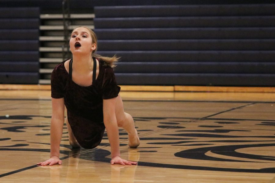 Performing her solo on Saturday, March 30, junior Sydney Ebner lifts her body from the floor.