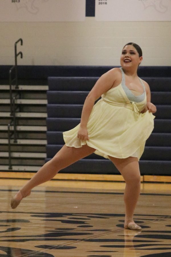 Dancing in the junior ensemble, junior Sammie Pennington fans out her dress.
