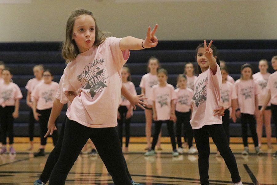 A young dancer throws out a peace sign during the Shining Stars dance at the spring show on Saturday, March 30.