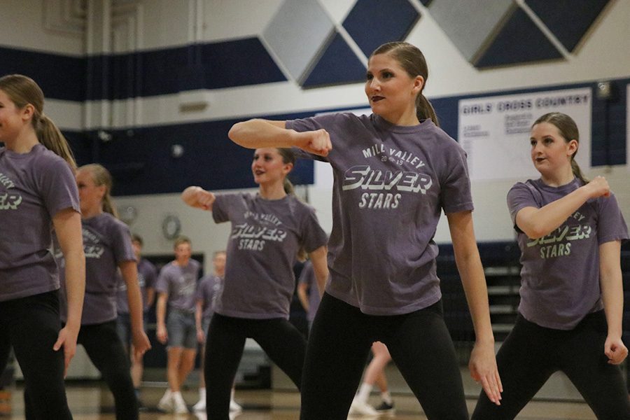 Pushing her arm out, senior Addie Ward performs with the Silver Studs on Saturday, March 30.