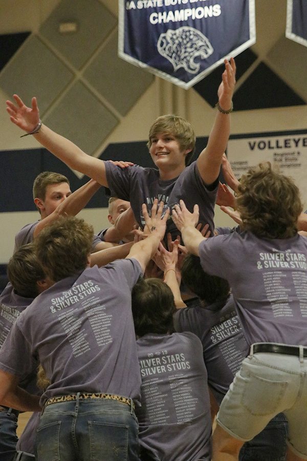 With Silver Studs gathered around him, senior Hunter Harris performs at the spring show on Saturday, March 30, reaching his arms toward the crowd.