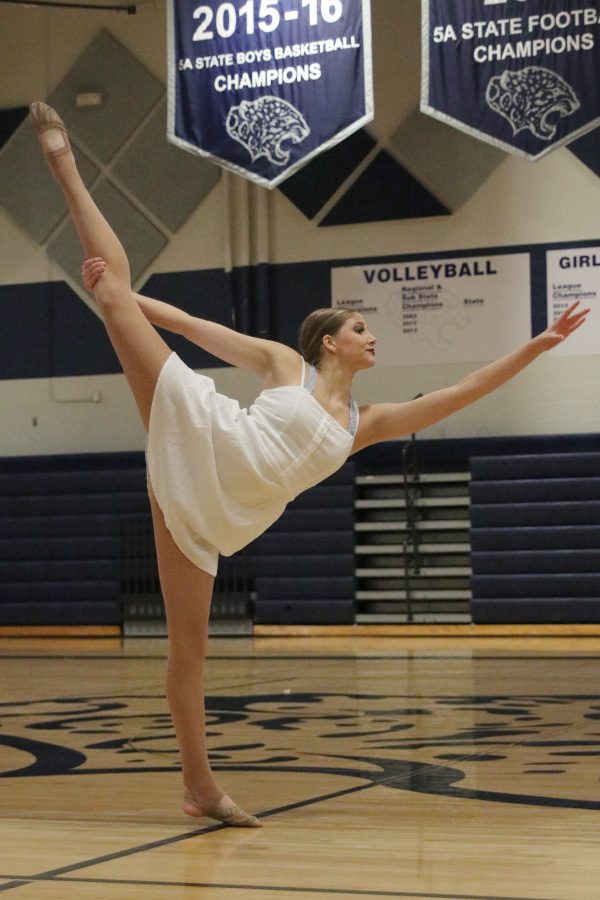 Kicking her leg back, senior Addie Ward performs her solo on Saturday, March 30.