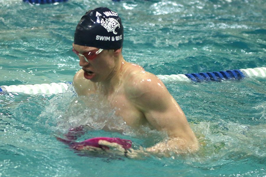 Swimming with paddles, senior Chris Sprenger practices his breast stroke form.
