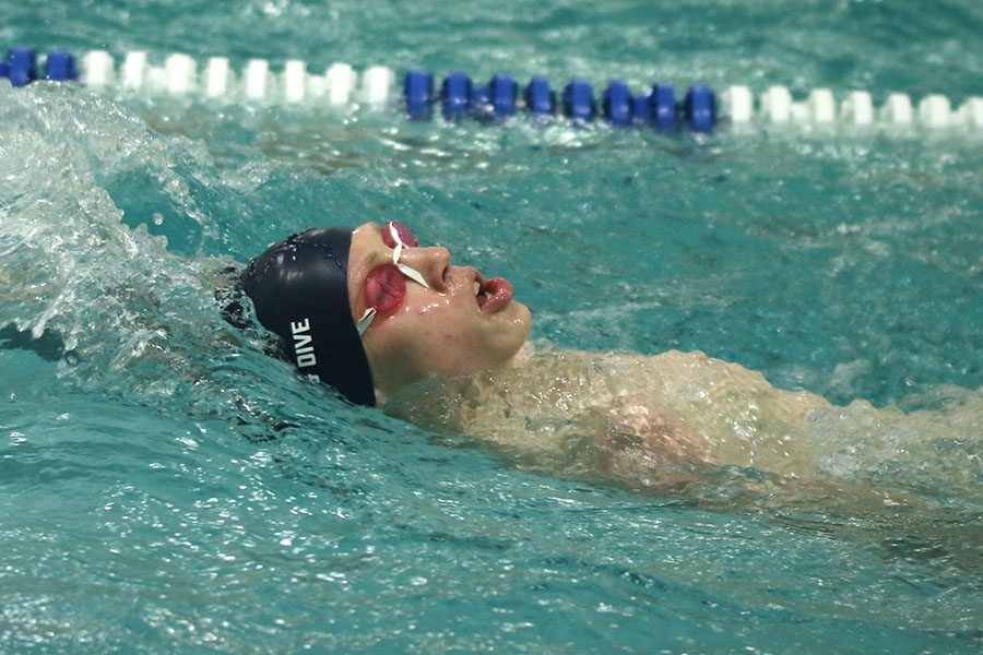 Reaching back, senior Chris Sprenger swims the breaststroke. 