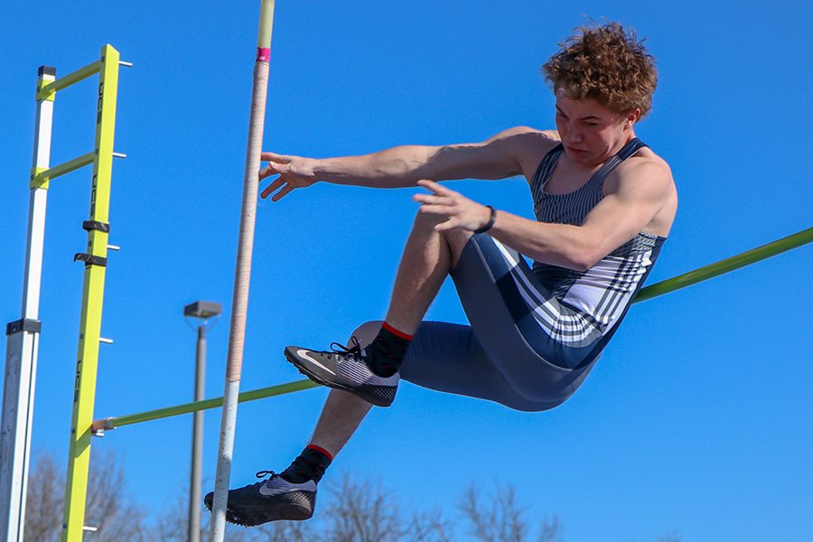 Facing backward after pole vaulting, senior Kaleb Shukeat hits the hight bar.