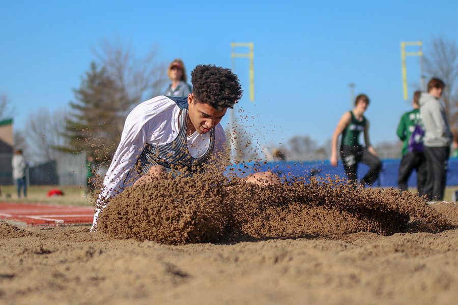 After sprinting down the runway, freshman Adrian Dimond lands in the sand in the triple jump event. 