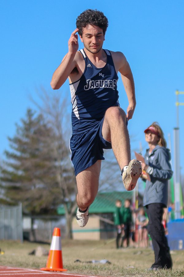 Looking at the sand, senior Francesco Spanakis prepares his landing in the triple jump. 