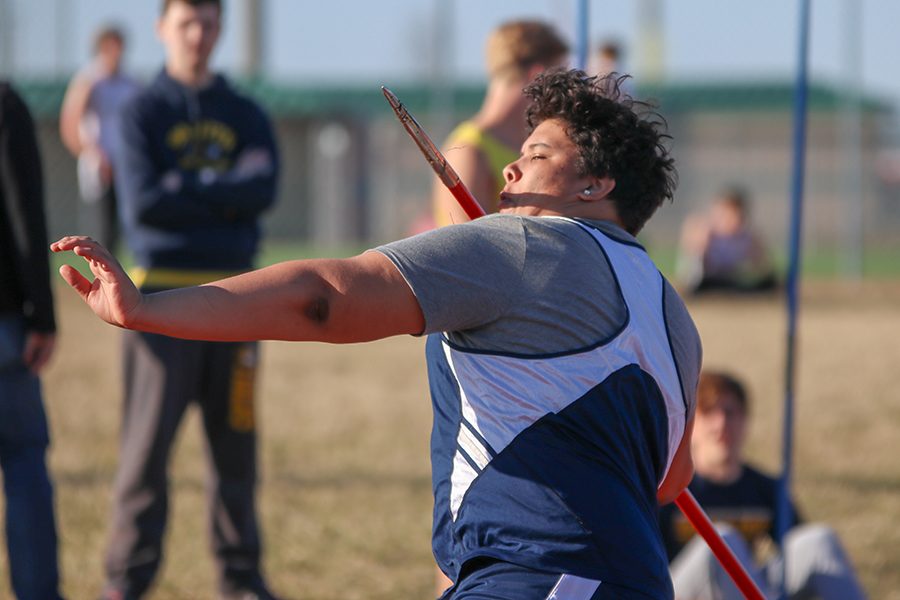 Looking down at his javelin, freshman Trey Cooper gets ready to release it. 