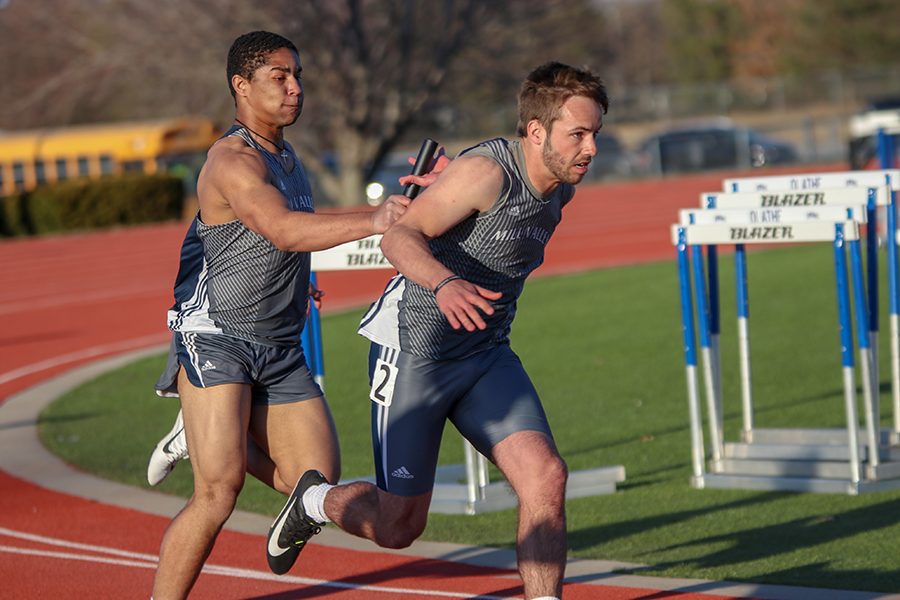 In turn four of the four by 100-meter relay, junior Tyler Green hands the baton off to sophomore Tyler Reishus. 