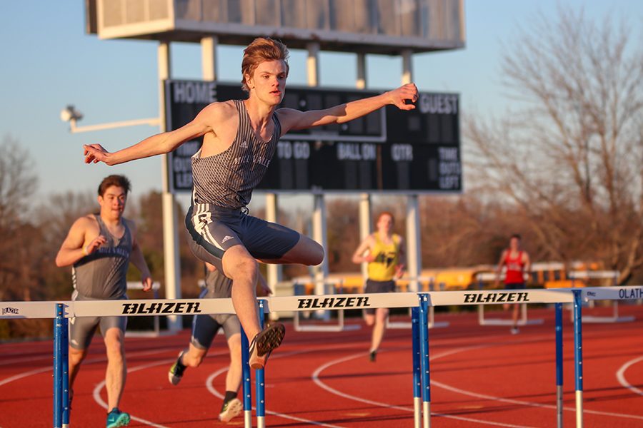 Coming out of turn four in the 300-meter hurdles, sophomore Leif Campbell jumps over the hurdle at the preseason quad meet on Thursday, March 21.   