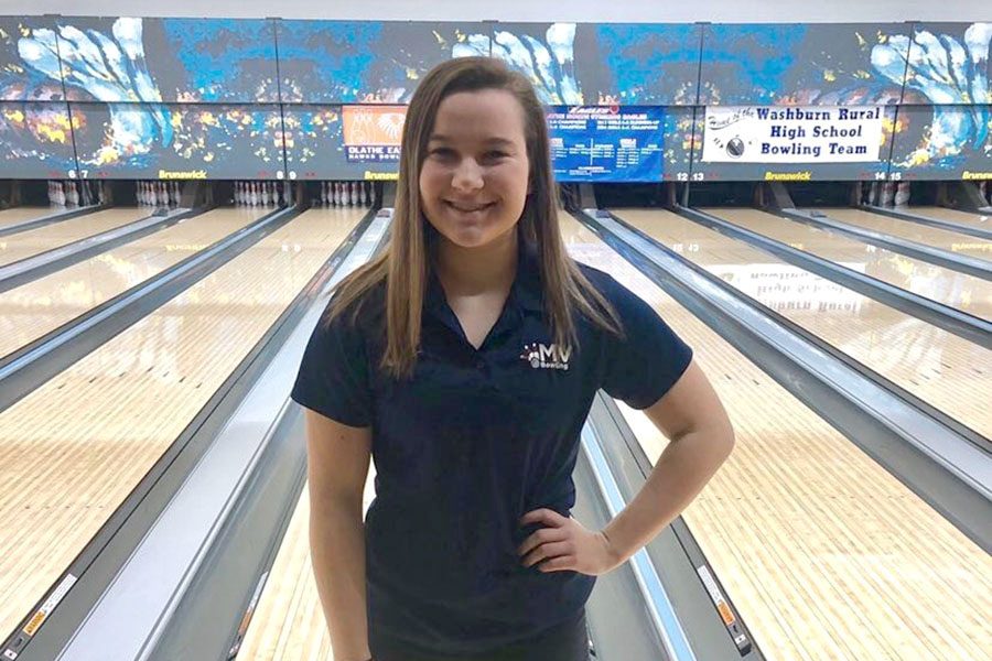 Before bowling at the state meet, junior Bri Laluk poses in front of the lanes.