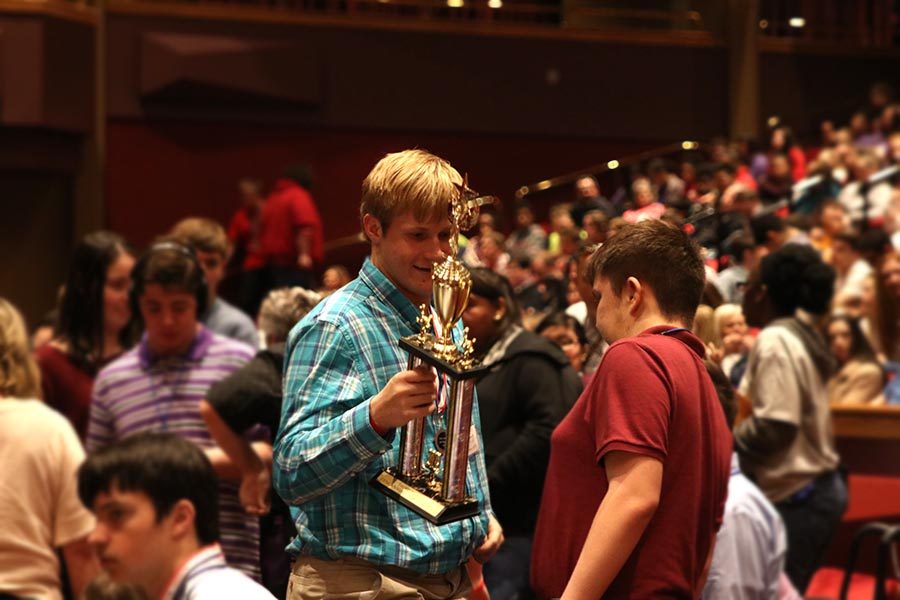 With a look of accomplishment on his face, senior Zach Dixon holds the third place first division trophy the Jaguars won at the Job Olympics on Thursday, March 28.
