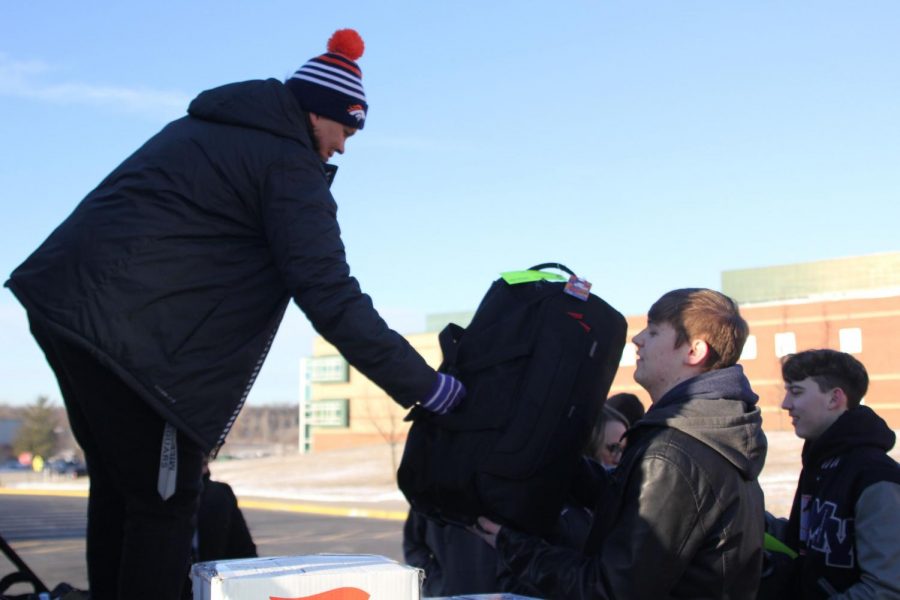 Gathered around the back of a truck on Thursday, March 7, junior Jacob Howe help load instruments onto the truck for the “Youre Instrumental Workshop” at Disney World, so they can be transported with assistant band director Elca Wagner to Orlando, Florida.