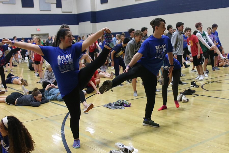 Trying to get into a yoga pose, sophomore Aaliyah Gonzalez and senior Johannes Seberger look to the instructor. 