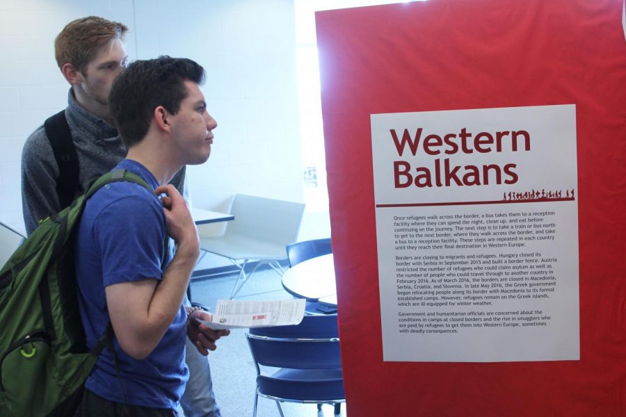 Hoping that the five items they chose at the beginning would help them survive, junior Braeden Wiltse and senior Tyler Jeanneret read information at the Western Balkans exhibit during the Youth for Refugees Simulation on Wednesday, March 27.