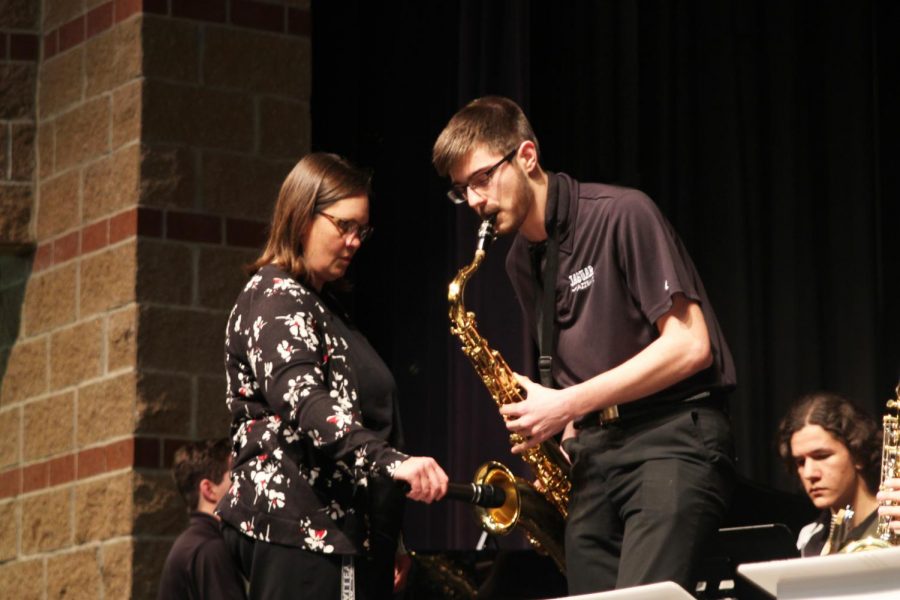 During the song “Hey Pachuco,” junior Adam Tilden performs a tenor saxophone solo while band director Deb Steiner holds a microphone to amplify the sound at the jazz band concert on Monday, March 25.