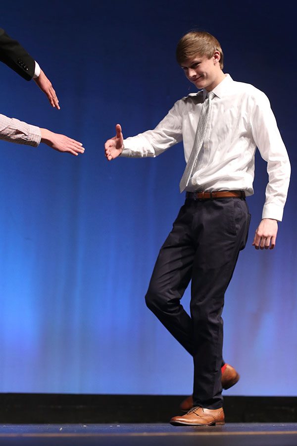 Walking on stage for the rose ceremony, senior Blake Aerni is greeted by the other contestants.