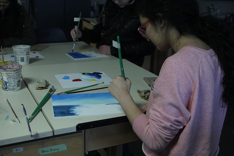 Holding her brush, freshman Natalia Hernandez paints along with Bob Ross.