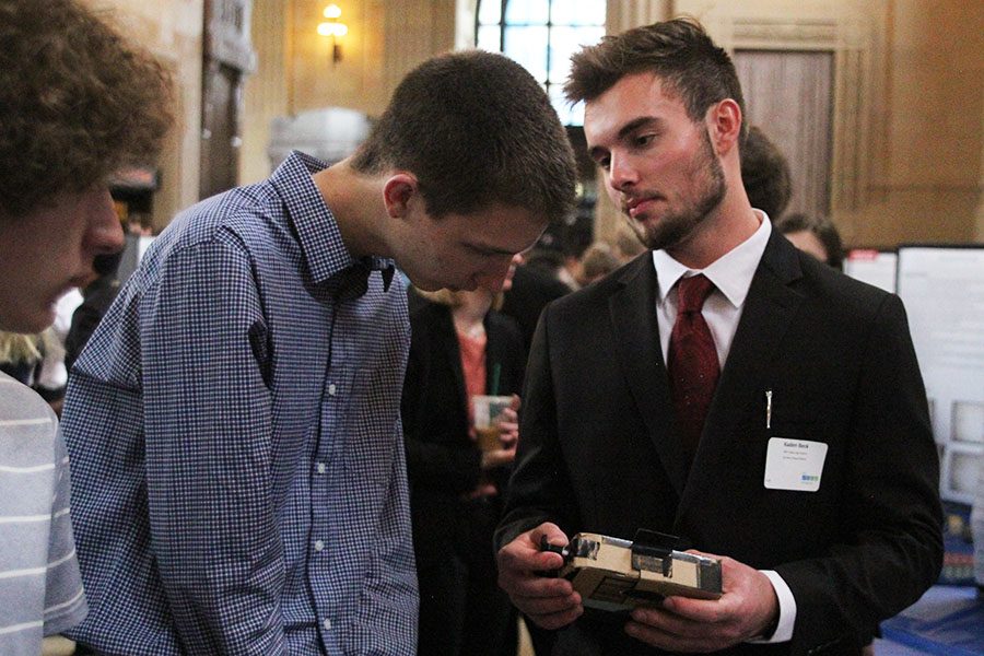 Demonstrating his project to an onlooker, senior Kaden Beck turns the knob on the side of his senior project, Cool Aide. The project seeks to keep refrigerated medications cold, which would be especially useful in areas seeking aid relief.