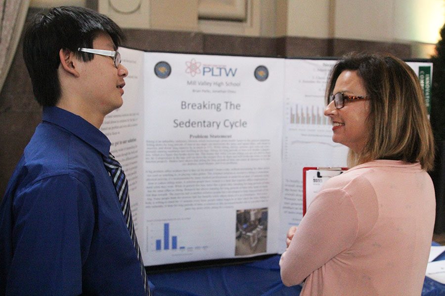 Senior Jonathan Chieu speaks with a judge about the sedentary cycle.