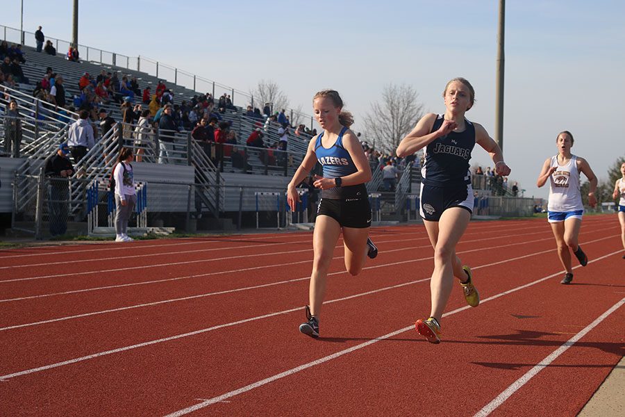 Head-to-head with her opponent, freshman Bridget Roy competes in the 1600 meter run.