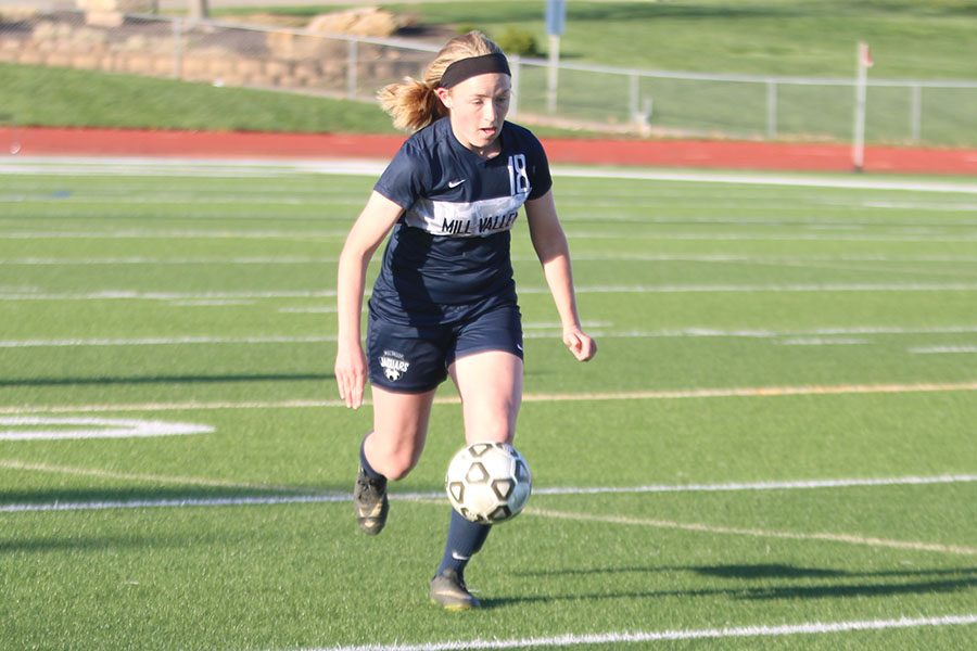 Dribbling her way towards the goal, junior Anna Ricker looks to extend the team’s lead.
