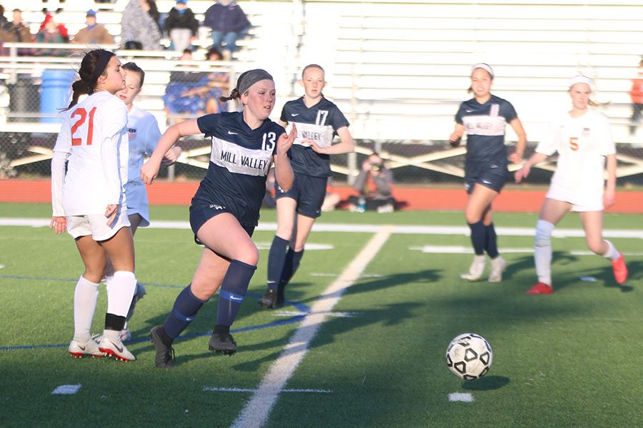 Making her way past two Shawnee Mission Northwest players, sophomore Paige Goetsch races towards the ball.
