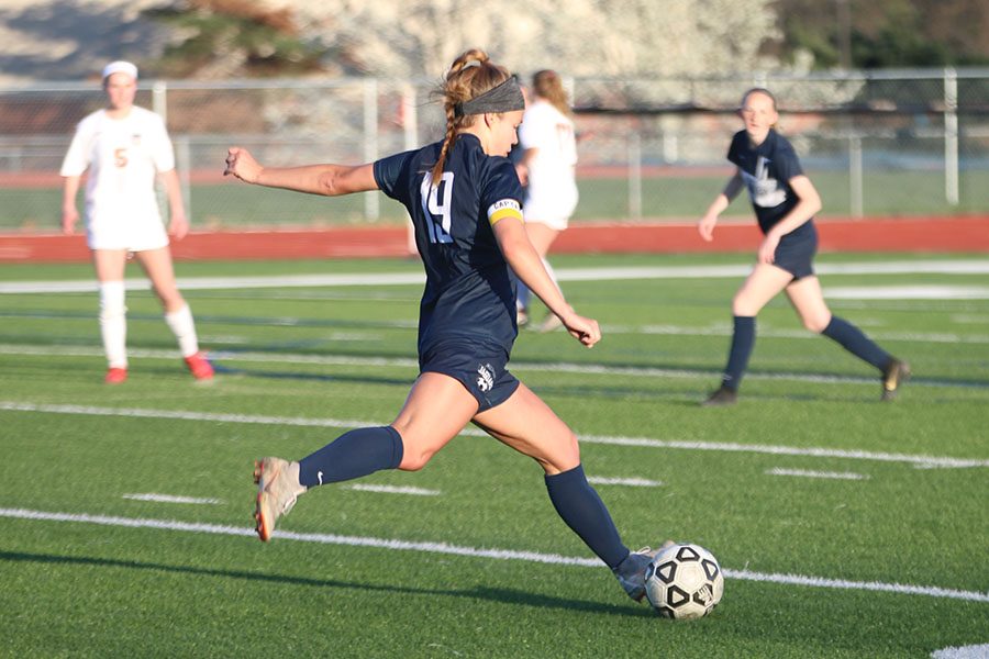 After getting the ball away from a Shawnee Mission Northwest player, junior Shyanne Best kicks the ball down the field.
