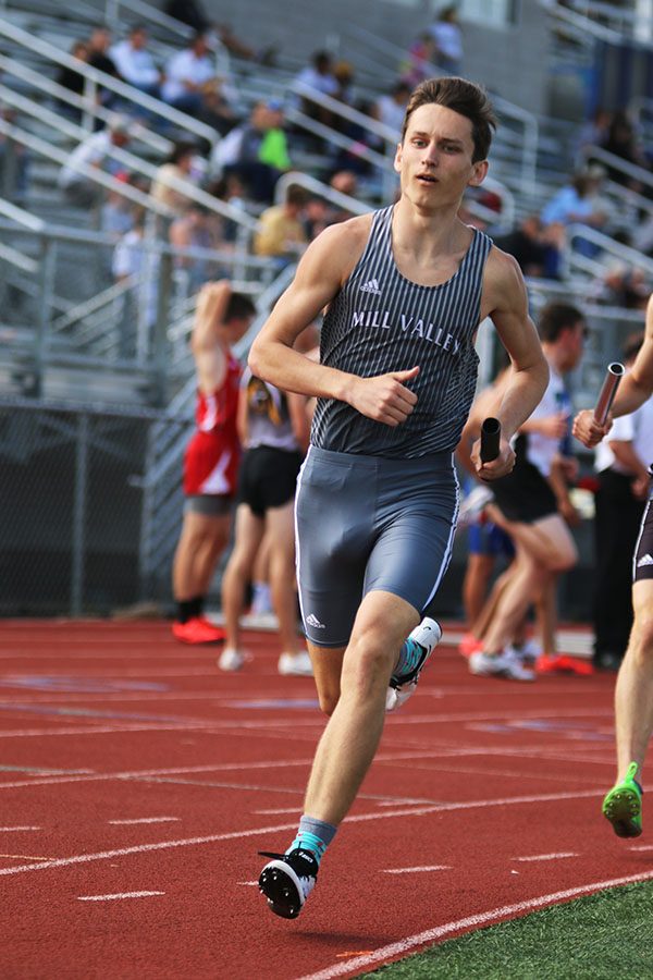 Holding his baton, junior Darius Hightower runs during the 4x800 meter relay. 