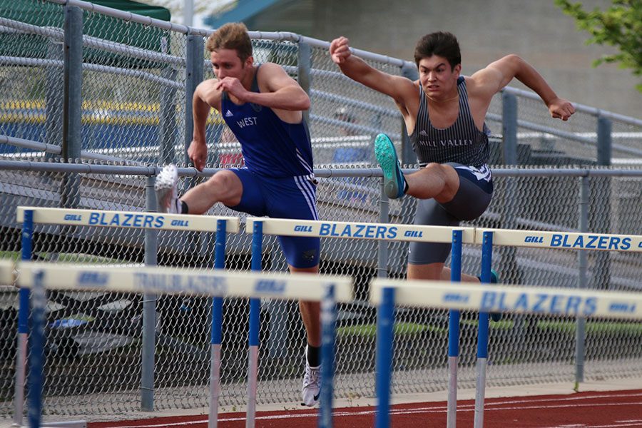 With his arms in the air, senior Eli Midyett jumps over a hurdle during the 110 meter hurdles race. Midyett finished fourth in the event. 