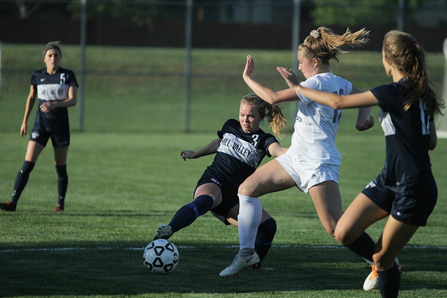 Reaching out with her leg, sophomore Lainey Waldron competes with BVSW player to regain possession of the ball and take it downfield.