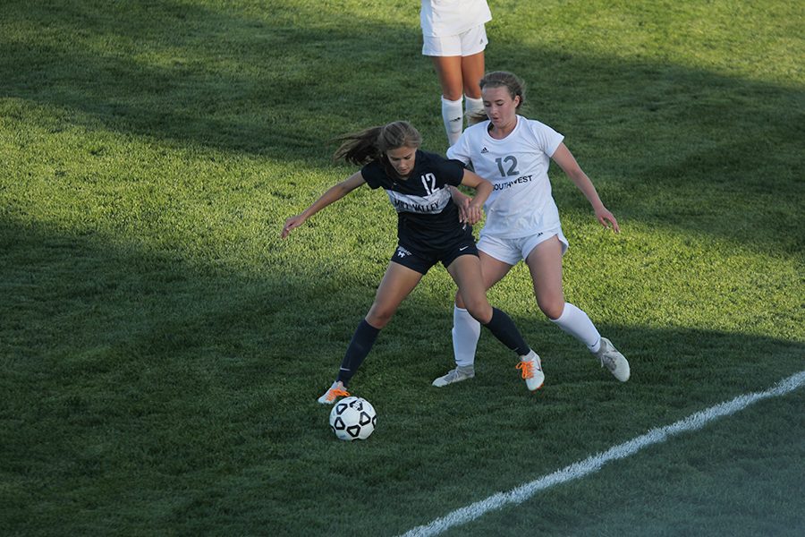 To prevent the ball going out of bounds, forward sopomore Avery Rutkowski shields it with her body from competing BVSW player.