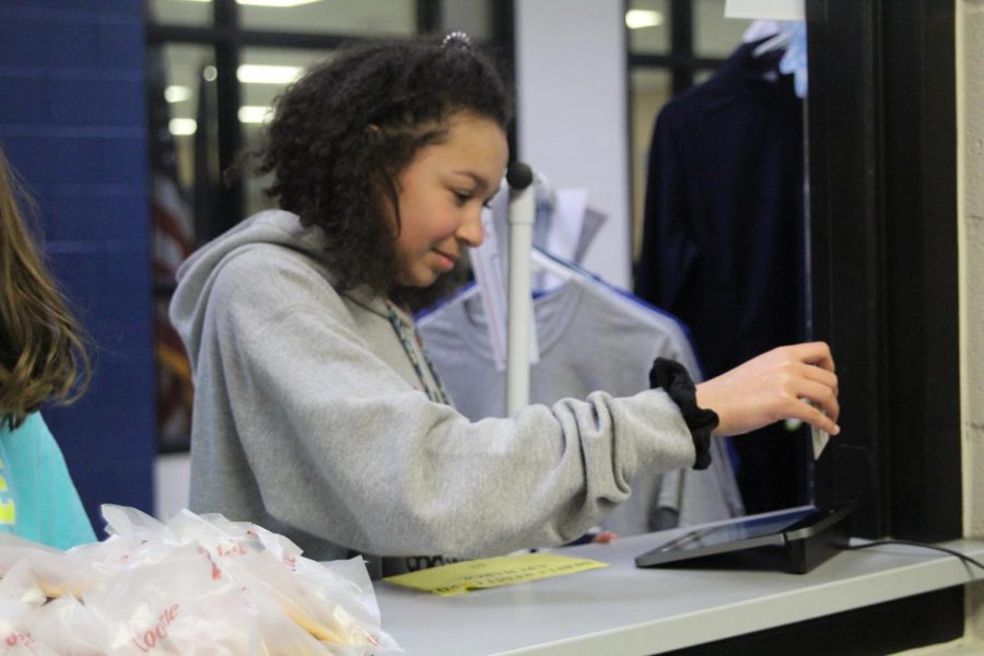 On March 28, sophomore Kaylee Corbit inserts her debit card into the new card reading system, the Square. With the new register system, the Catty Shack now accepts card paying methods.