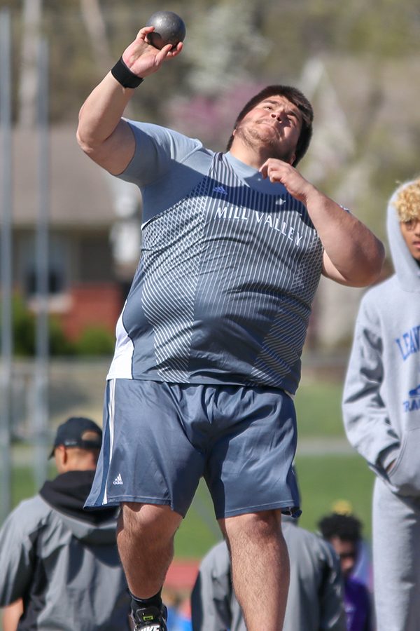 Looking towards the sky, junior Justin Sanders throws the shot put. 