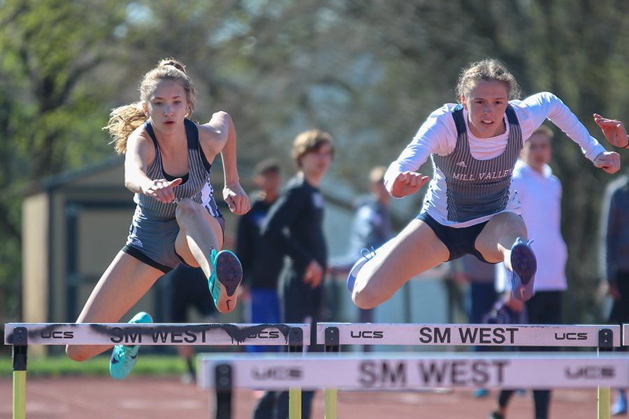  Looking down towards the next hurdle, freshman Reese Johnston and senior Erin Miller compete in the 100-meter hurdles. 