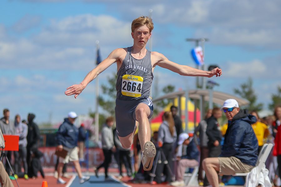 Focusing on the sand, senior Harry Ahrenholtz competes in the triple jump. 