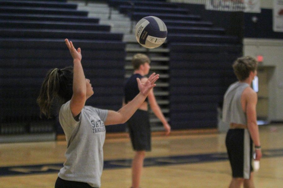 Preparing to serve, senior Mya Johnston tosses the ball into the air.