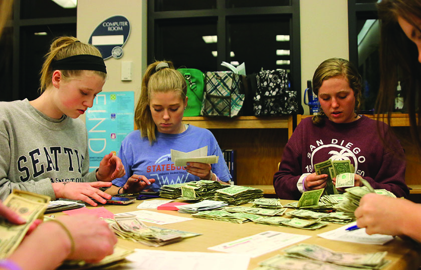 At bank night on Wednesday, March 27, juniors Megan Proctor, Gabrielle Fitterer and freshman
Damara Stevens count money turned in by team captains.