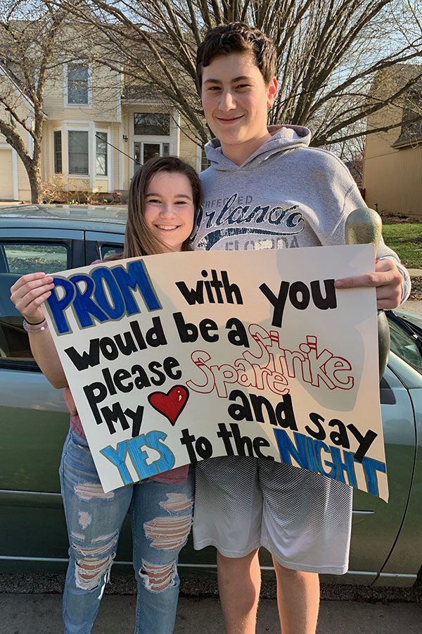 Holding a sign with his prom date junior Bri Laluk, sophomore Jackson Penny poses for a photo.

