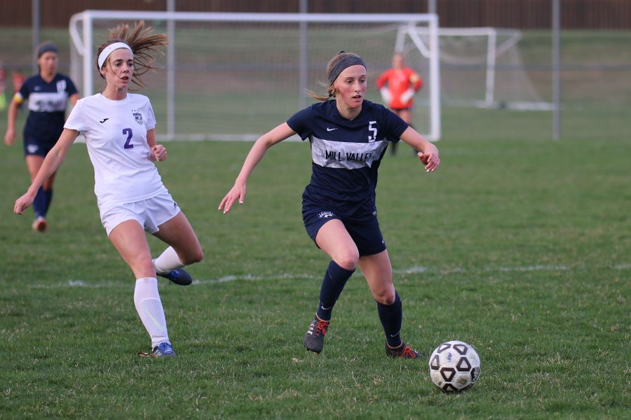 Racing toward the ball, junior Annie Hoog moves the ball away from the goal.