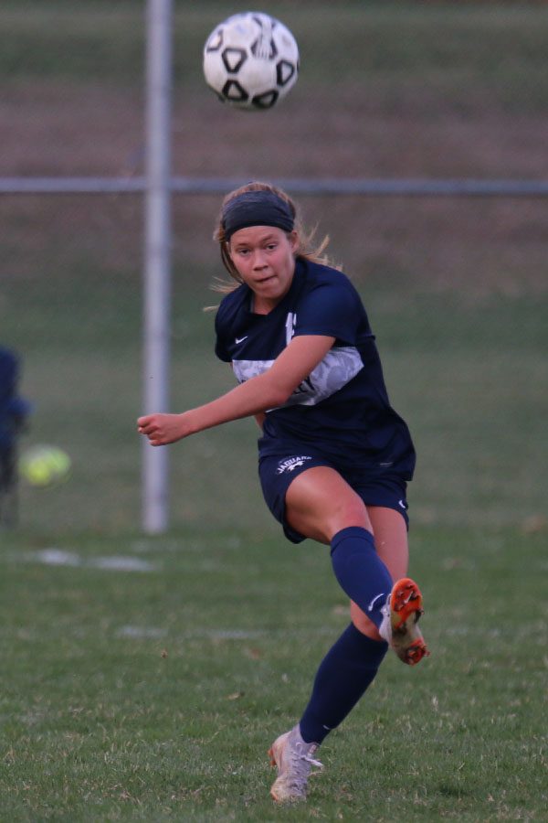 Eyes locked down the field, senior Shyanne Best kicks the ball.