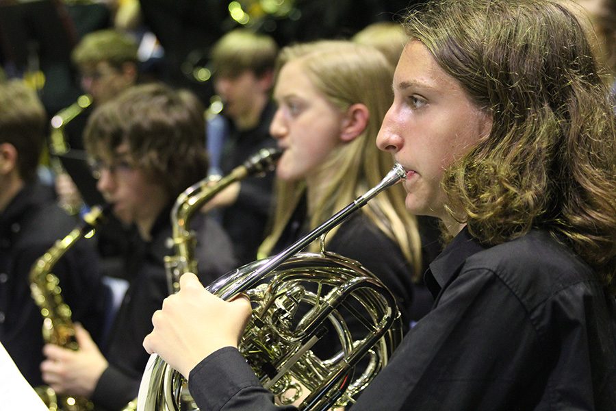 Tuning his french horn, Freshman Cameron Long prepares to perform for the judges.