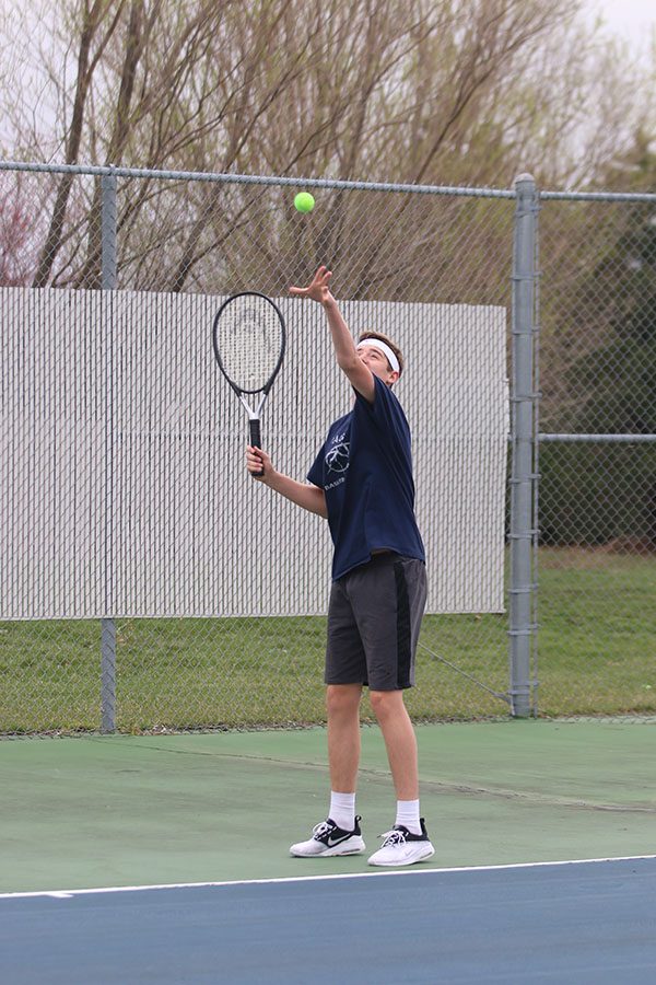 Throwing the ball in the air, sophomore Aaron Kephart gets ready to serve. 
