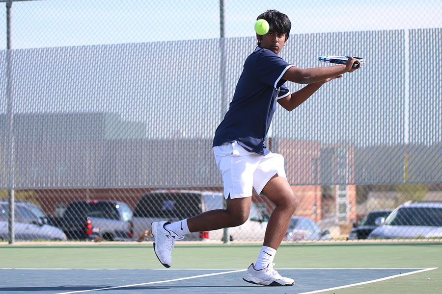 After a strong return from his opponent, junior Manoj Turaga winds up for a backhand.