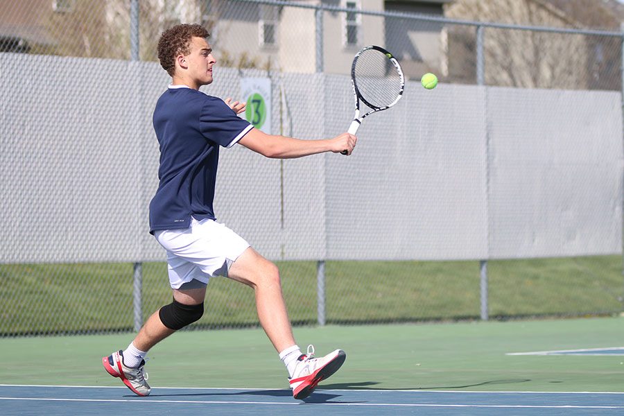 Lunging towards the ball, junior Aidan Thomas prepares for a slice.