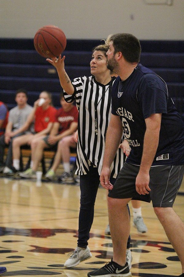 At the start of the Student vs. Faculty game on Tuesday, April 30, English teacher Coral Brignoni tosses the ball up for tip off.