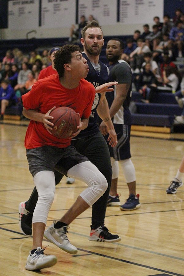 Positioning himself in front of paraprofessional Kody Cook, senior Matt Wittenauer prepares to shoot a basket during the Student vs. Faculty game on Tuesday, April 30.