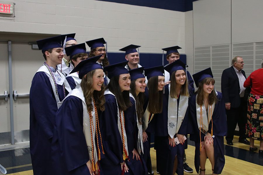 After the graduation ceremony, a group of friends poses for a group photo.