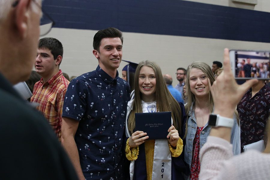 Graduate Emily Proctor poses with her siblings for a photo.
